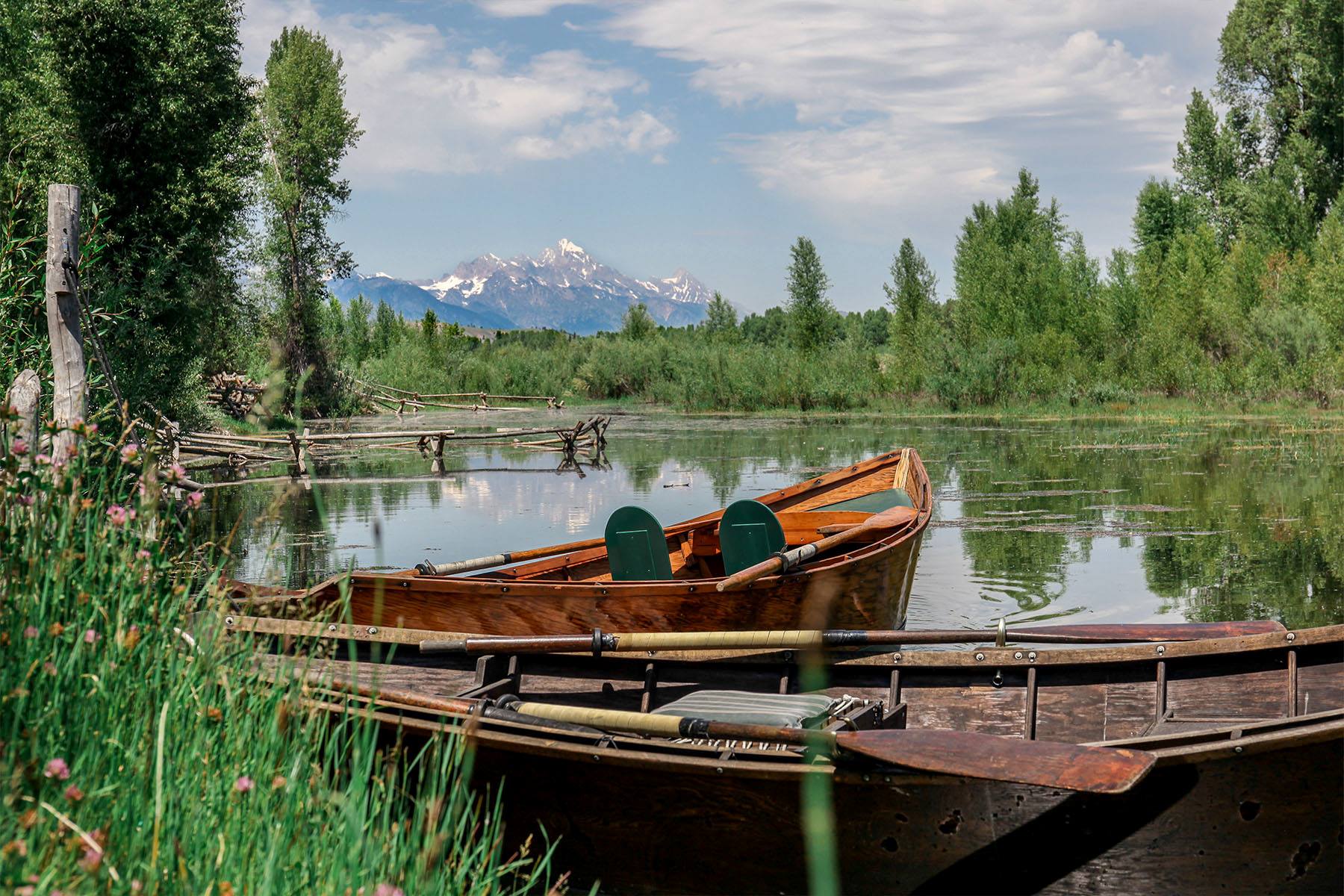 Wooden boats floating on river with mountain background